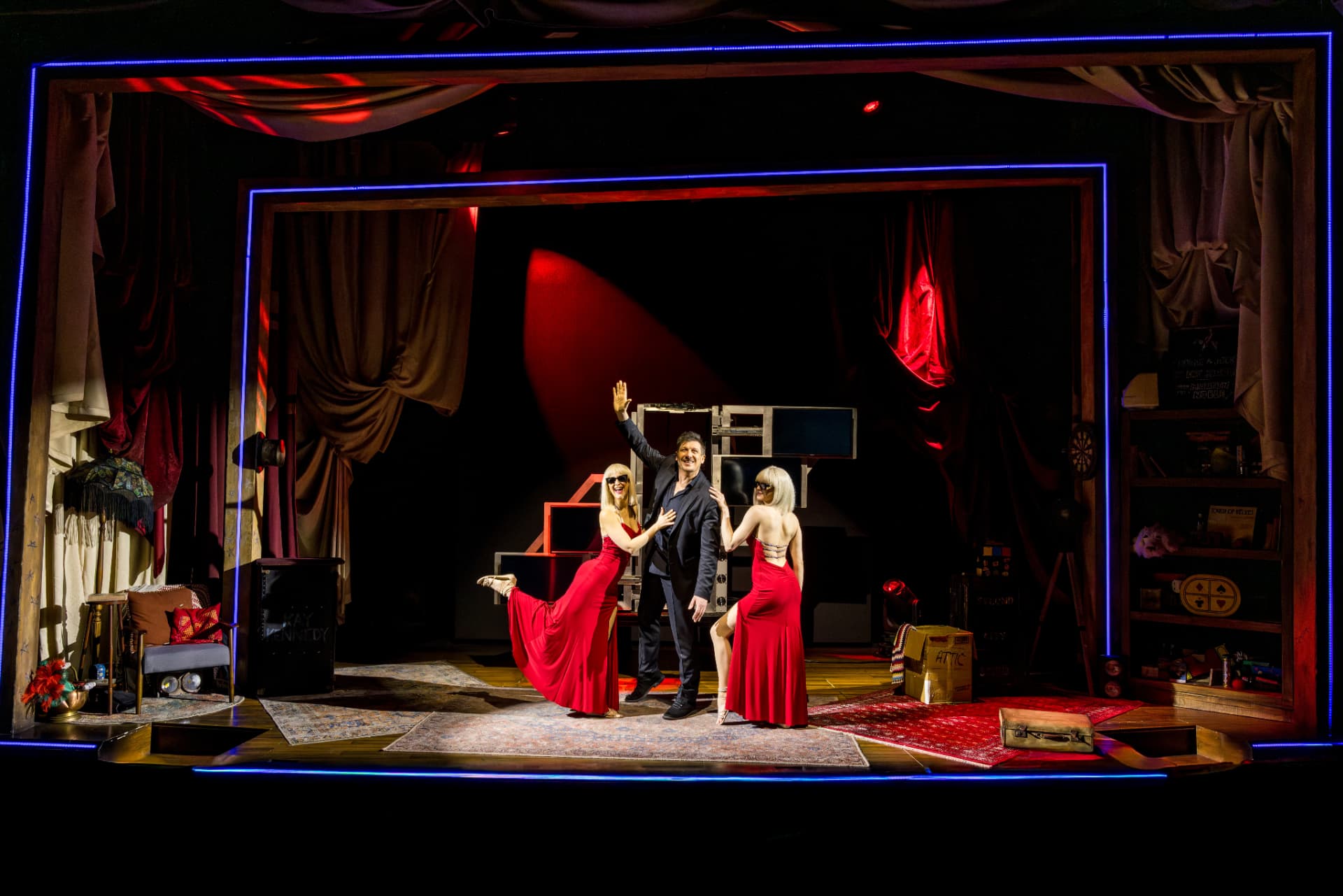 Jamie Allan with two performers in red gowns