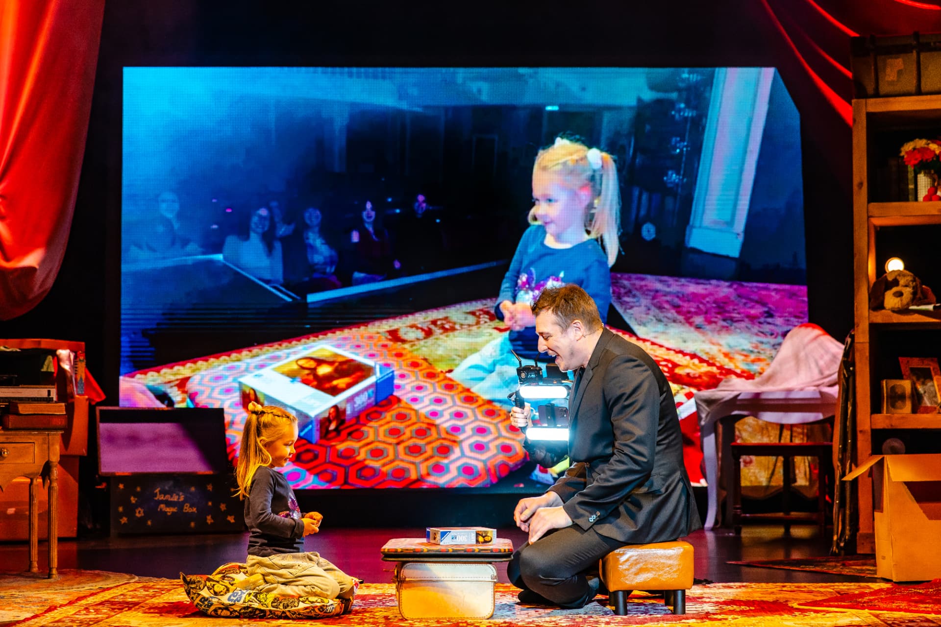 Jamie Allan performing magic with a young audience member
